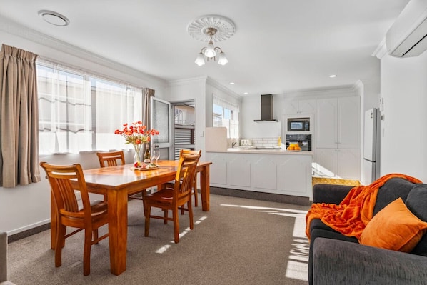 Un appartement moderne comprenant un coin repas, une cuisine et un salon.