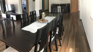 Un vaste espace dédié à la salle à manger, avec une longue table, de nombreuses chaises et un élément décoratif central.