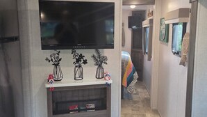 A modern kitchen with a built-in oven, a flat-screen TV, and a clock on the wall. - Sunshine Serenity @ Crystal River, Florida (Crystal River)
