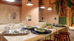 A well-lit dining area with a marble countertop, two wine glasses, a silver tray, and a green napkin. - Charming Loft in the Historic Center (Centro Histórico Salvador)