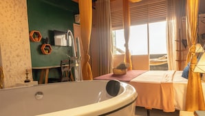 A room with a bathtub, a bed, a television, and a window with curtains. - Charming Loft in the Historic Center (Centro Histórico Salvador)