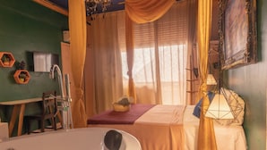A room with a bathtub, a bed with yellow curtains, a bedside lamp, and a painting on the wall. - Charming Loft in the Historic Center (Centro Histórico Salvador)
