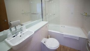 A modern bathroom with a sink, toilet, and bathtub.