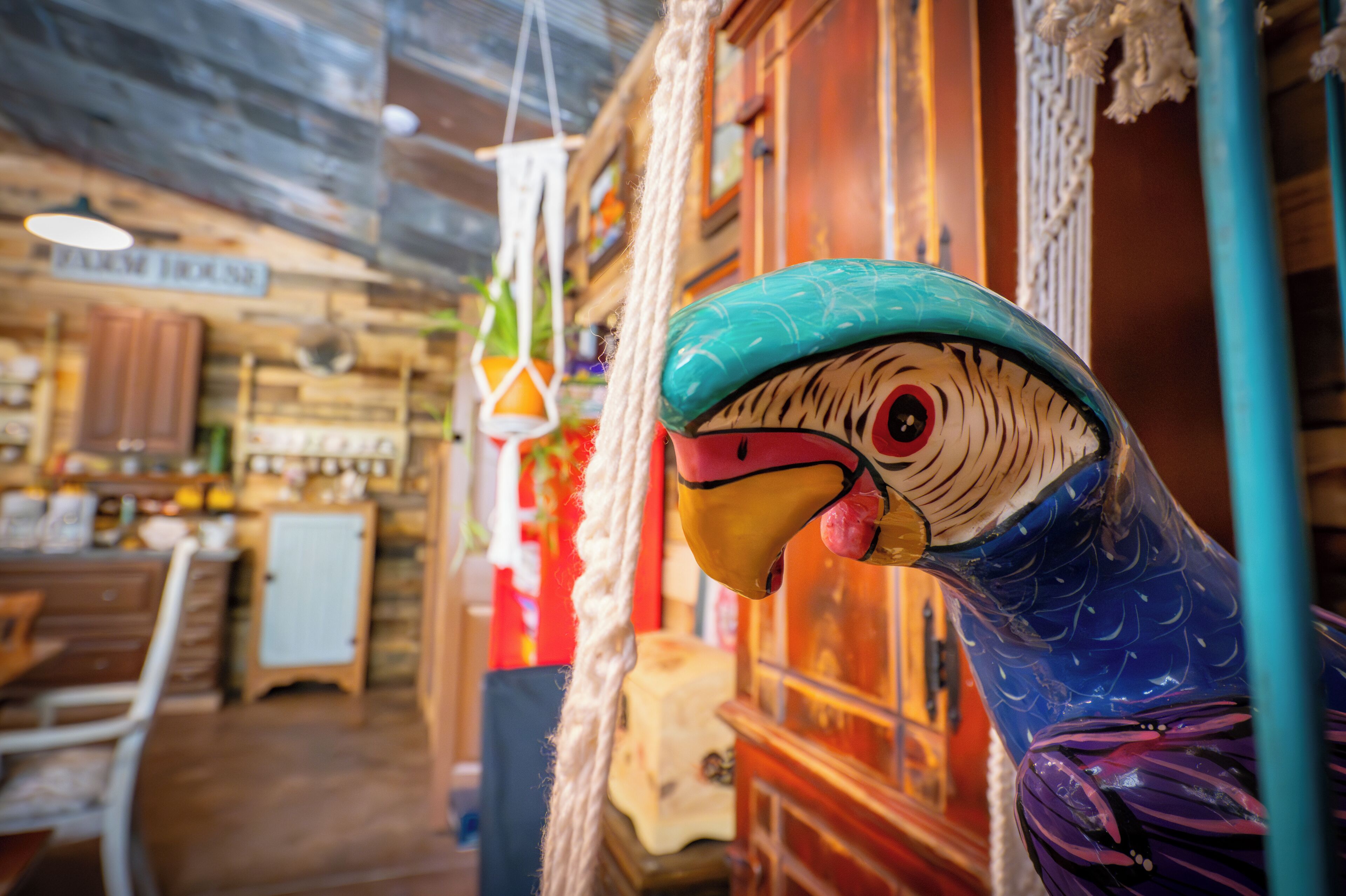 A rustic interior with wooden walls, a hanging light fixture, and a decorative bird sculpture.