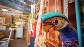 A rustic interior with wooden walls, a hanging light fixture, and a decorative bird sculpture.