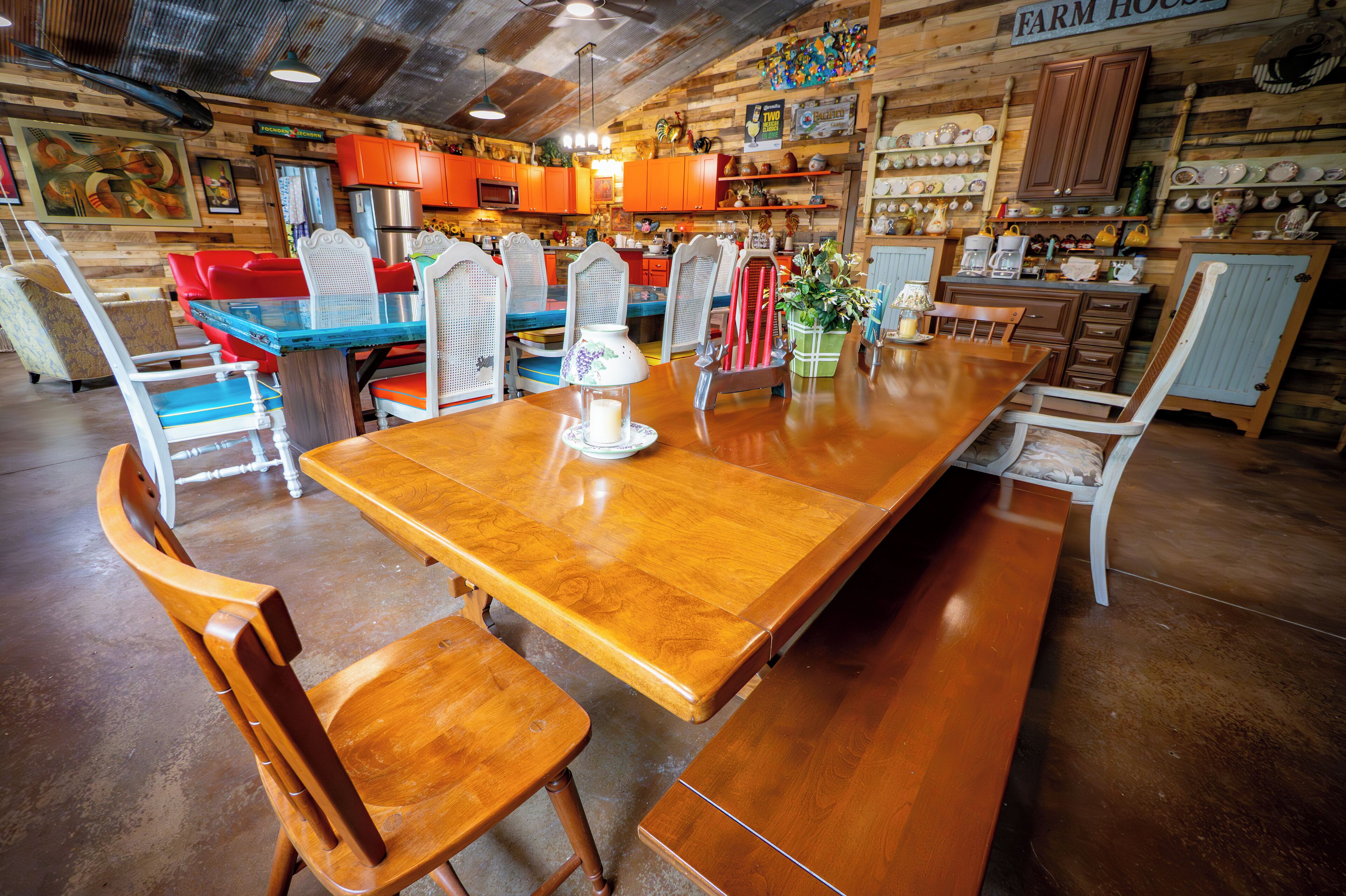 Un coin repas rustique avec une table et des chaises en bois, entouré d’armoires et d’étagères en bois où sont rangés les ustensiles de cuisine.