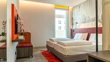 A modern bedroom with a bed, bedside table, and a red rug.