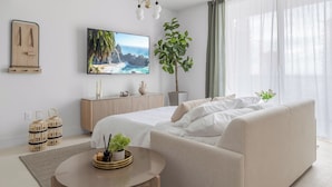 A modern bedroom with a bed, a sofa, a TV, and a large window. - 3701 - Kaseya Center 2 Bedroom Modern Apt with Pool & Gym in Downtown Miami (Miami)