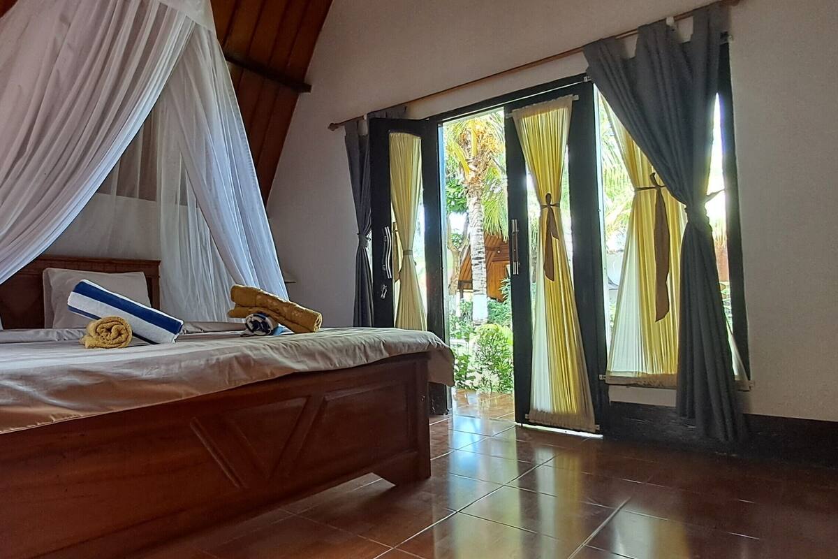 A bedroom with a wooden bed, white bedding, and a canopy.