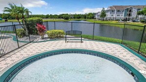 A swimming pool with a tiled edge, surrounded by a brick patio and a metal fence. - Adventure's at Villa Del Sol (Kissimmee)