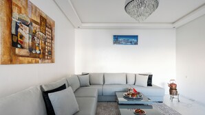 Ein modernes Wohnzimmer mit einem Ecksofa, einem Couchtisch und einer Pendelleuchte.