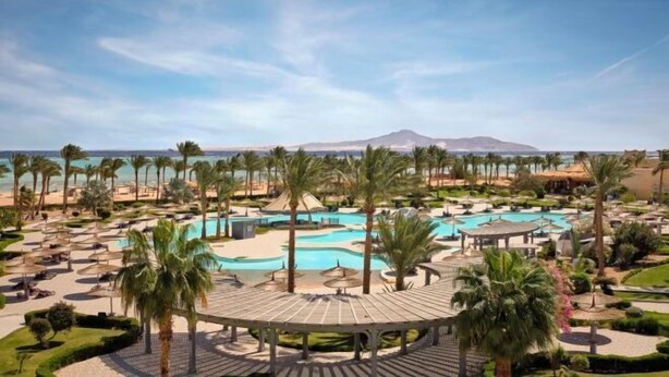 A resort with multiple swimming pools, palm trees, and a beach area. - Coral Sea Waterworld Sharm El Sheikh (Qesm Sharm Ash Sheikh)