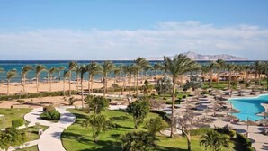 A resort with a pool, palm trees, and a beach. - Coral Sea Waterworld Sharm El Sheikh (Qesm Sharm Ash Sheikh)