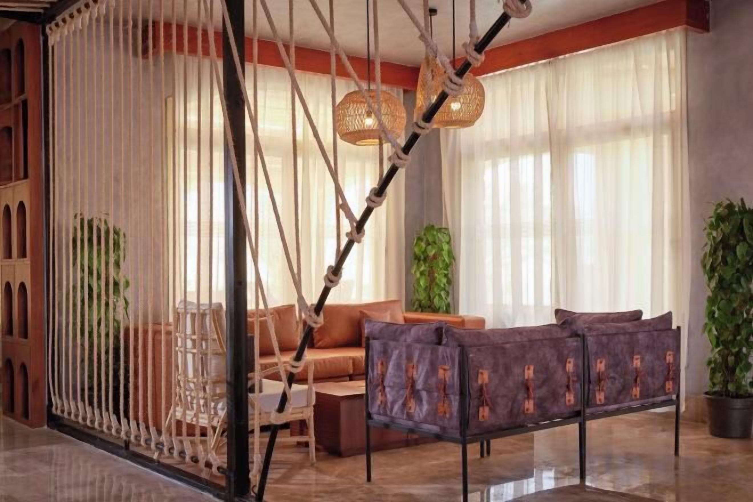 A modern living room with a sofa, a coffee table, and a hanging light fixture.