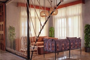 A modern living room with a sofa, a coffee table, and a hanging light fixture.