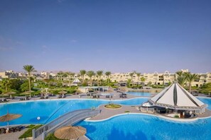 A resort with a large swimming pool, a bridge, and a pavilion.