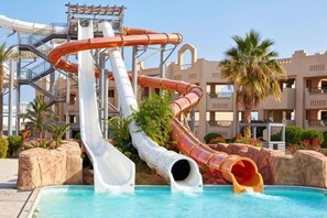 Parque acuático con múltiples toboganes y piscina.