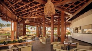 A spacious outdoor dining area with wicker furniture and a wooden ceiling structure. - Coral Sea Waterworld Sharm El Sheikh (Qesm Sharm Ash Sheikh)