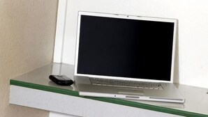 A laptop on a white table with a green edge.