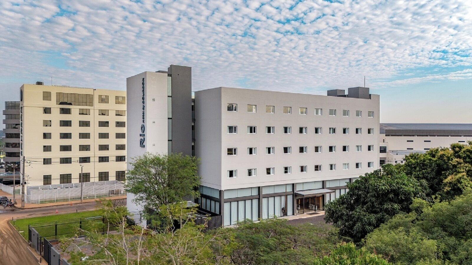 A modern building with multiple floors, large windows, and a flat roof.