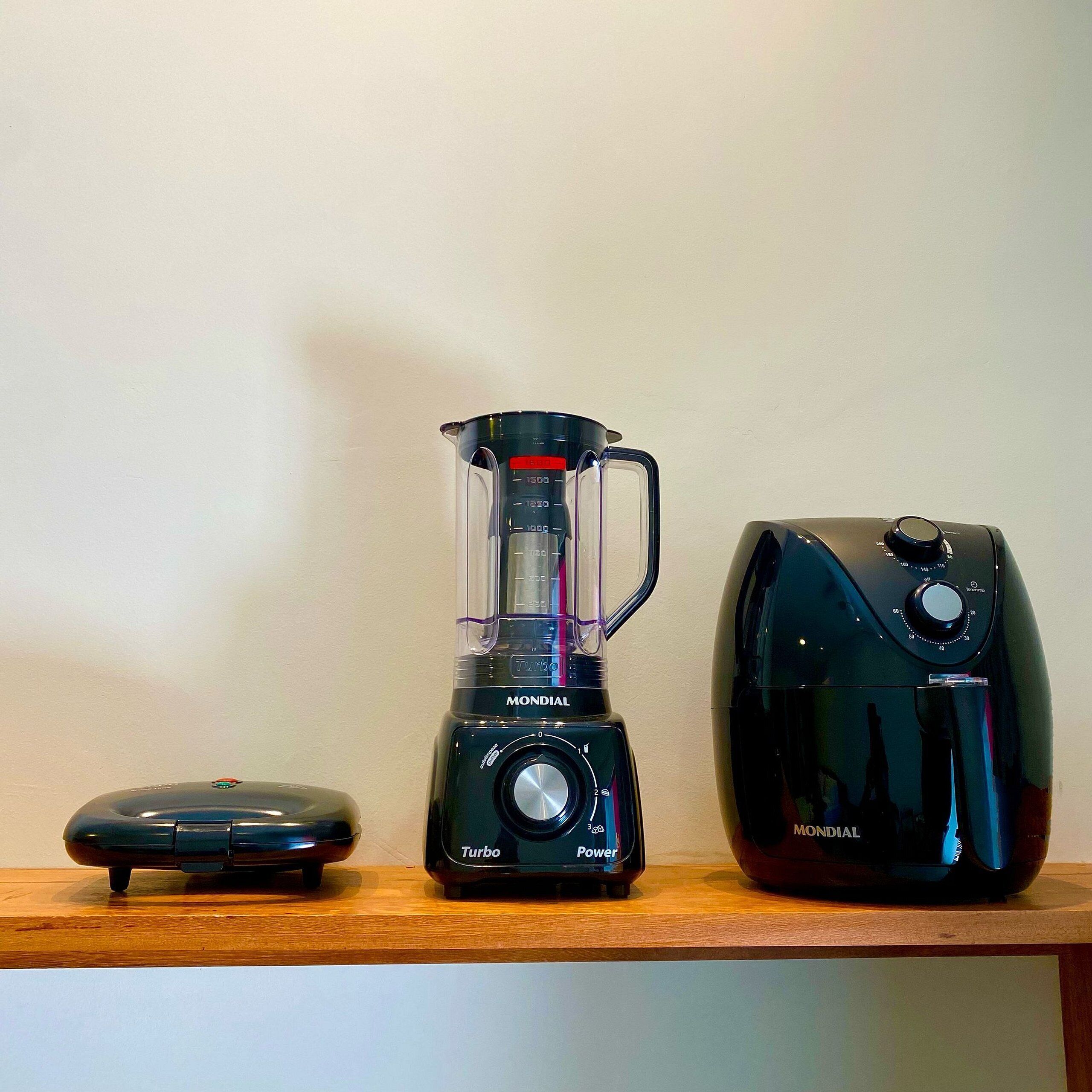A kitchen counter with a blender, a food processor, and a coffee maker.