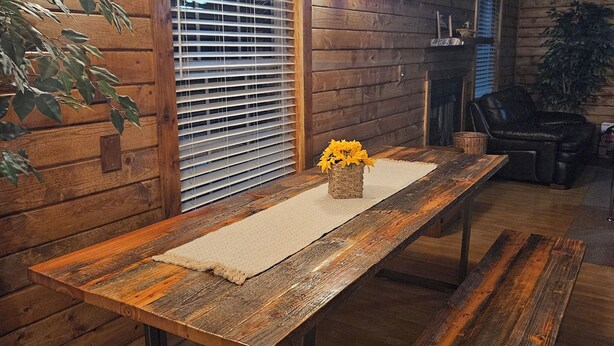 A wooden interior with a long table, benches, and a window with blinds. - Charming 3-bedroom cottage in Oxford with WiFi and AC close to Wisconson Dells (Oxford)