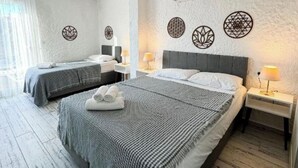 A hotel room with two beds, a large window, and a ceiling fan. - Ambers Alaçatı (Cesme)