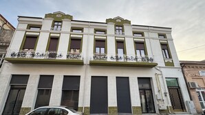 A multi-story building with a balcony, large windows, and a car parked in front. - JMR Splendor-Private Sauna & Bathtub Sui (Constanta)