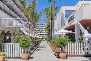 A hotel corridor with a white fence, potted plants, and a giraffe statue. - Innside Alcudia (Alcudia)