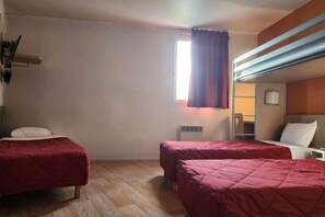 Una habitación con dos camas, una ventana con cortinas, una mesita de noche y una lámpara.