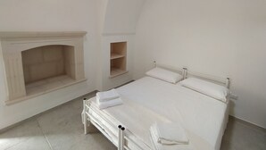 A bedroom with a bed, a fireplace, and a sloped ceiling.