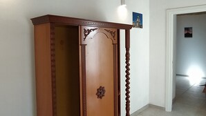 A wooden cabinet with a decorative top and a small picture above it.