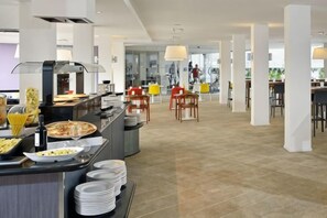Ein moderner Hotel-Speisesaal mit Buffet, darunter eine Pizza-Station und verschiedene Speisen.