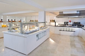 A modern buffet setup with a glass partition, a variety of food items, and a clean, well-lit interior. - Innside by Meliá Ibiza (Ibiza)