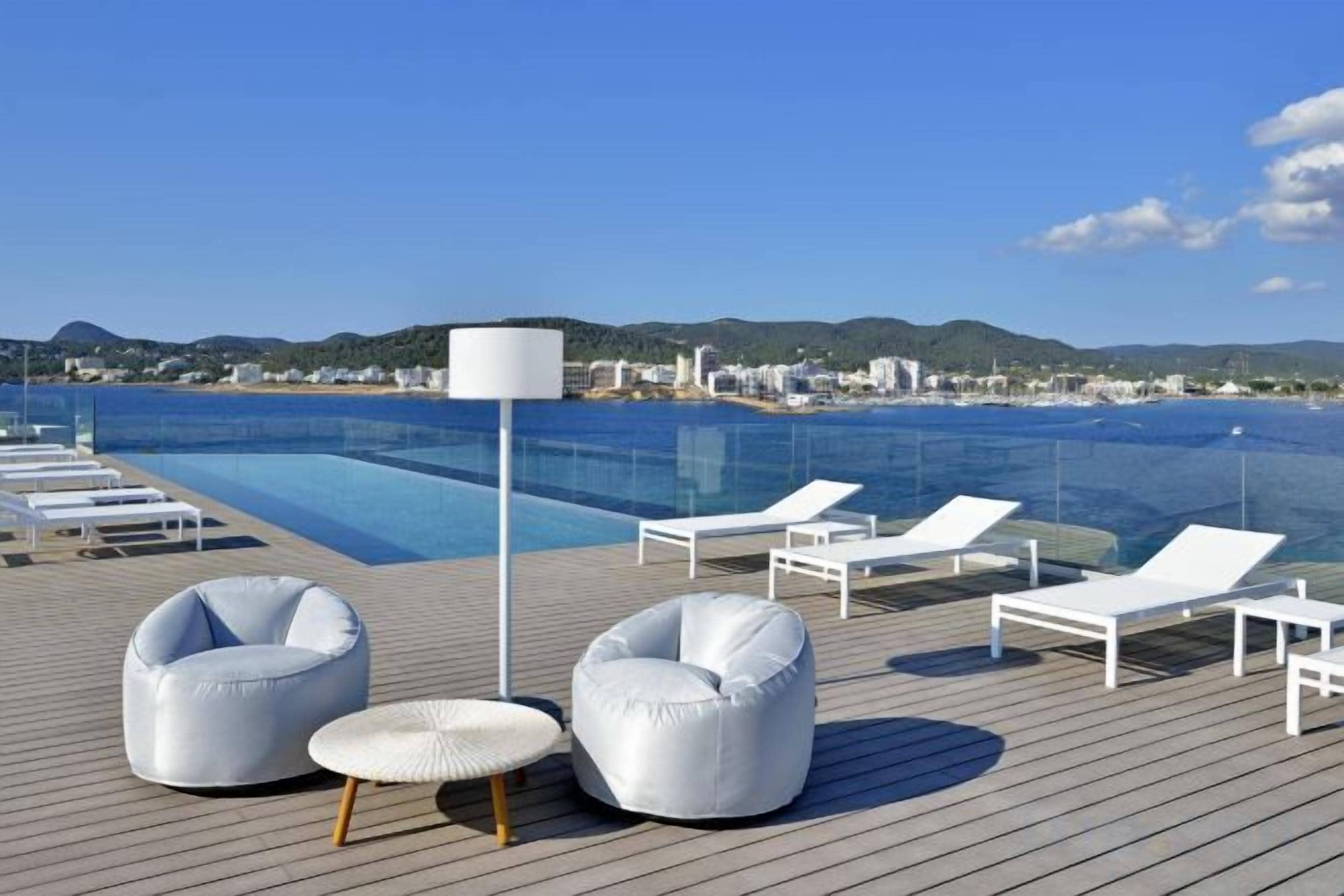 A poolside area with lounge chairs and a lamp.
