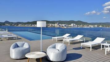 A poolside area with lounge chairs and a lamp.