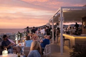 An outdoor seating area with tables and chairs, overlooking a scenic view. - Innside by Meliá Ibiza (Ibiza)
