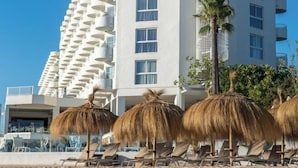 A beachfront hotel with multiple balconies, thatched umbrellas, and sun loungers. - Innside by Meliá Ibiza (Ibiza)