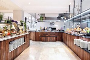 Cocina moderna con encimera de madera, electrodomésticos de acero inoxidable y una variedad de alimentos a la vista.
