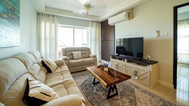 Una sala de estar moderna con sofá, mesa de centro y televisor.