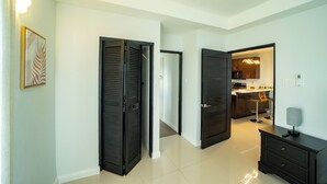 Un interior moderno con una zona de cocina, una mesa de comedor y un taburete de bar.