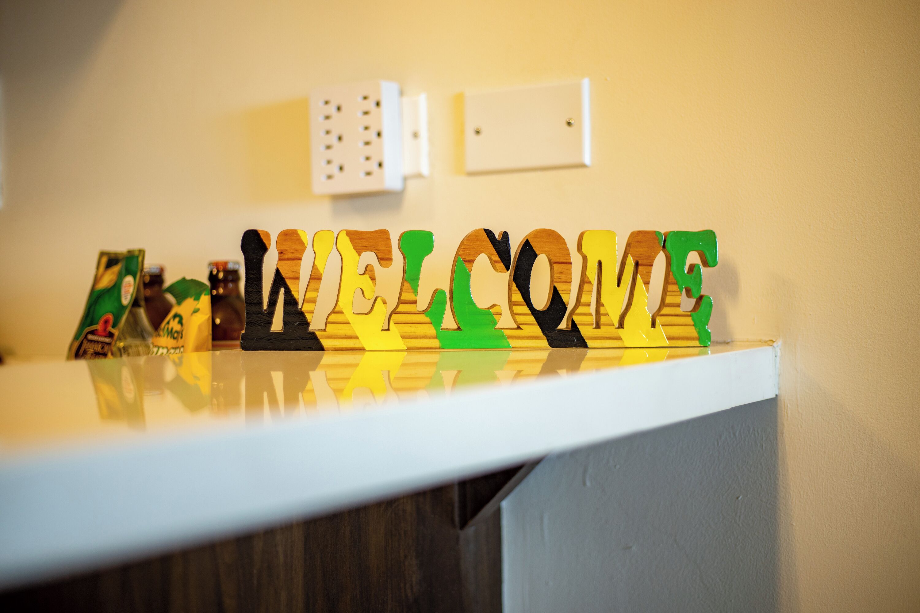 Un comptoir d’accueil avec une pancarte « BIENVENUE » composée de lettres aux couleurs vives.