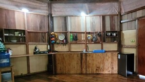 A kitchen with wooden cabinets, a sink, and various kitchen utensils. - Amaca Eco Station (San Juan Bautista)