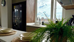 A kitchen with a window view, a refrigerator, and a sink. - VOU by Wellcome (Bogotá)
