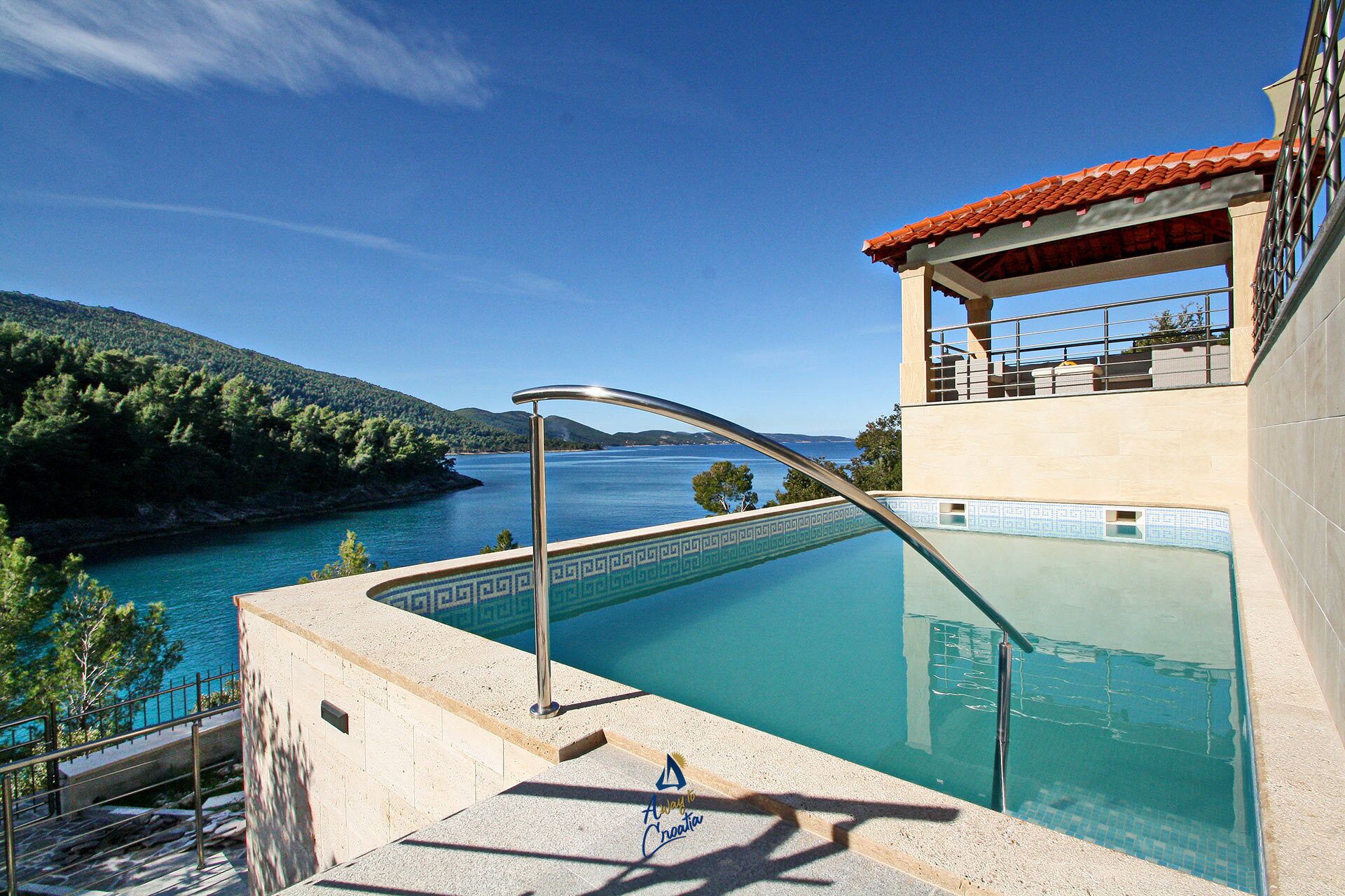 A pool with a view of a lake and hills.