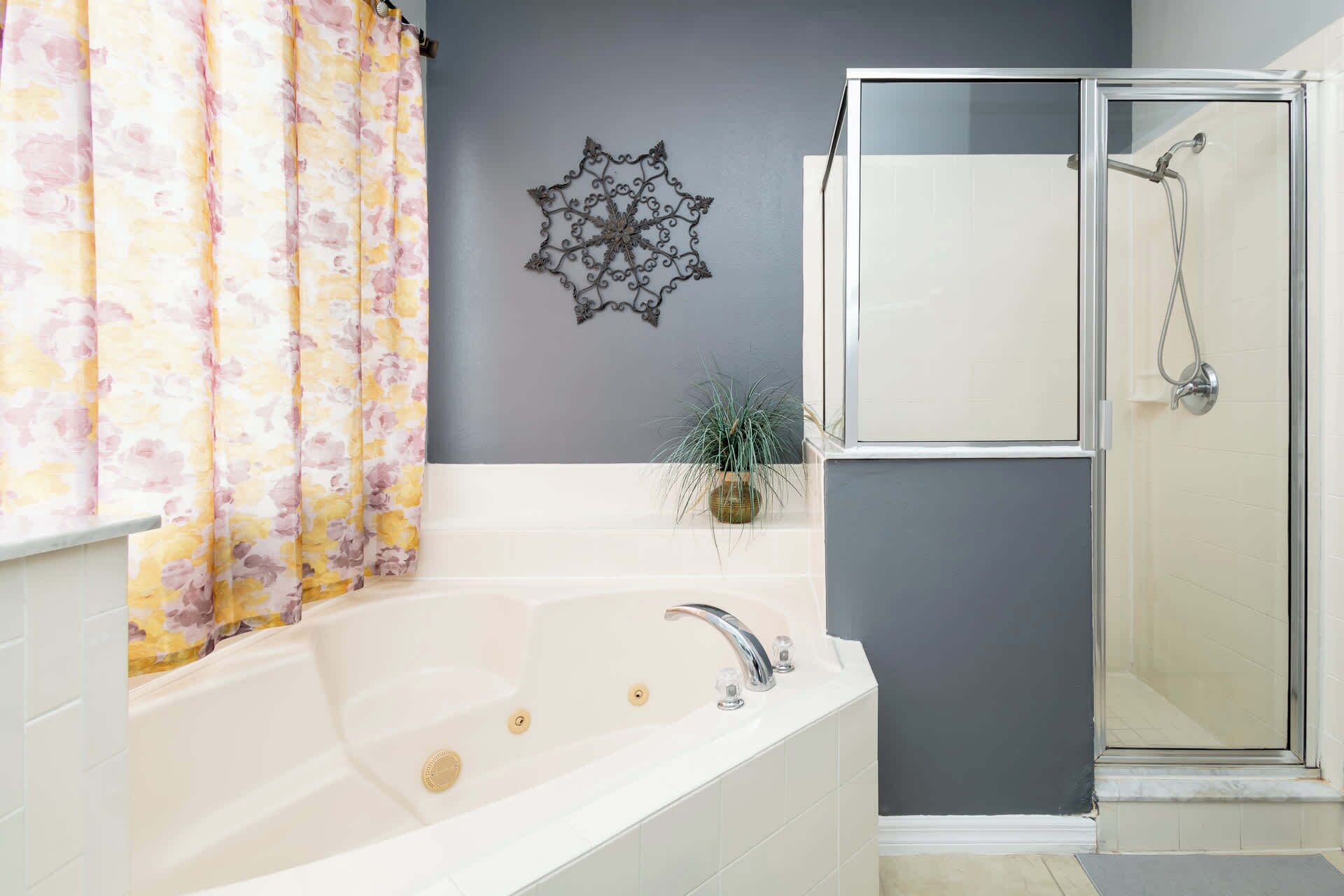 A bathroom with a bathtub, a shower, and a decorative wall piece.