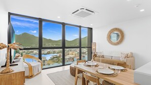 Ein moderner Essbereich mit großem Fenster und Blick auf Stadtpanorama und Hügellandschaft.