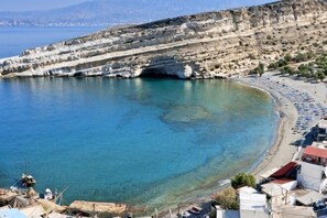 A coastal town with a beach, rocky cliffs, and clear blue sea. - Matala Dimitris Resort (Matala)