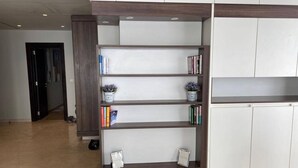 Ein Empfangsbereich mit einem Holzbüro, einer weißen Theke und einem Bücherregal mit Büchern und Dekoration.