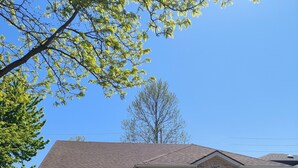 A two-story house with a garage, a front porch with chairs, and a stop sign in the background. - Perfect 3 bedroom house in prime location of South Windsor. max 5 guests (Windsor)